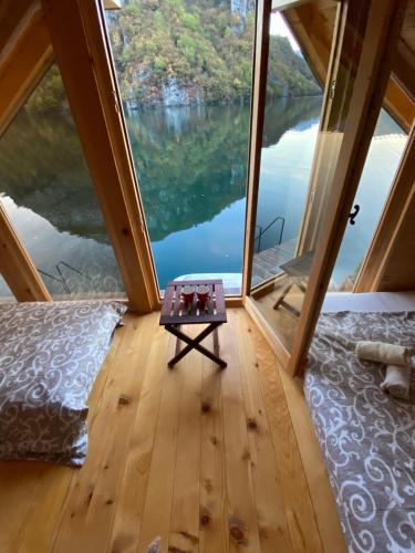 a room with a view of a lake from inside a tent at Floating House Perućac in Perućac