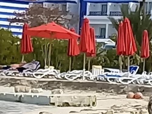 a group of umbrellas and chairs on a beach at Porto marina luxury flat for families onlyشاليه فاخرداخل بورتو مارينا in El Alamein