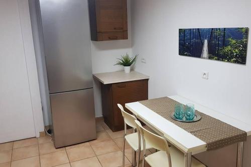 Il comprend une cuisine équipée d'une table, de chaises et d'un réfrigérateur. dans l'établissement Appartement de 50m2, climatisé avec terrasse et parking, à Castelnau-le-Lez