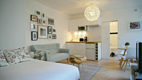 uma sala de estar com uma cama e uma cozinha em Little Suite - Oscar em Lille