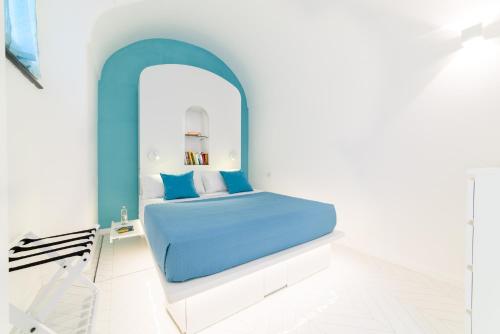 - une chambre blanche avec un lit bleu dans l'établissement Casa Andreana, à Amalfi