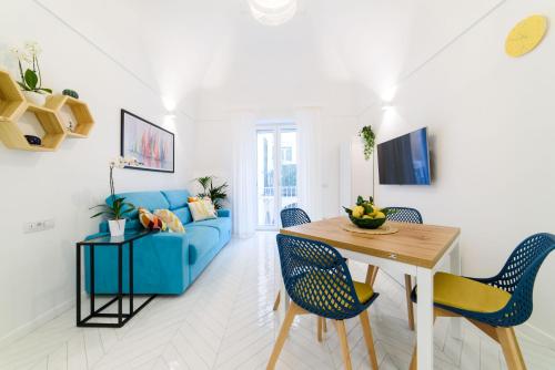 a living room with a blue couch and a table at Casa Andreana in Amalfi