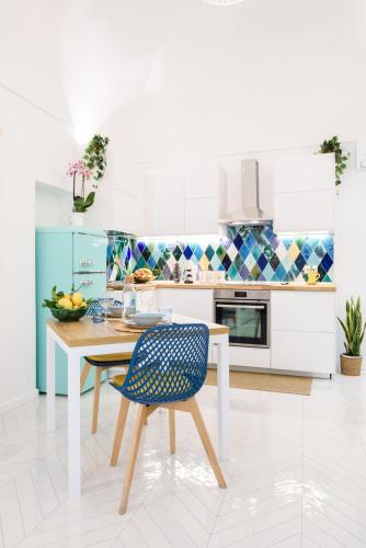a kitchen with a table and a blue chair at Casa Andreana in Amalfi