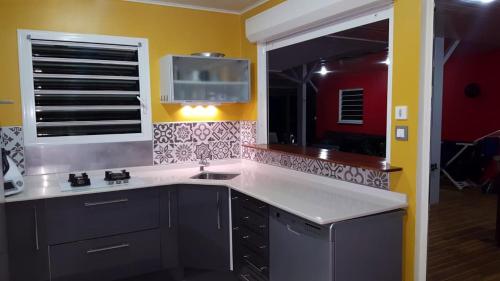 a kitchen with a sink and a large window at Villa élégante avec jardin au Lamentin et piscine privée. in Le Lamentin