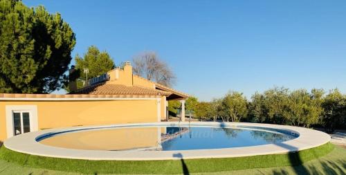 a large swimming pool in front of a house at Casa Rural Tablas de Daimiel in Daimiel