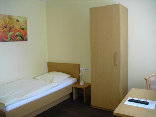 a small bedroom with a bed and a table at Boardingroom in Filderstadt