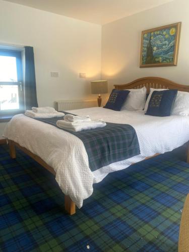 ein Schlafzimmer mit 2 Betten und Handtüchern darauf in der Unterkunft Ben View Aberlour Luxury Barn Conversion in Aberlour