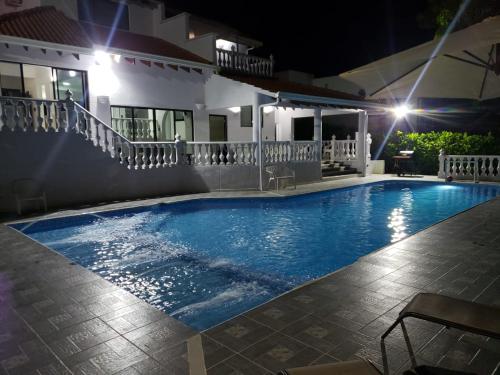 a swimming pool in front of a house at night at Casa campestre in Melgar