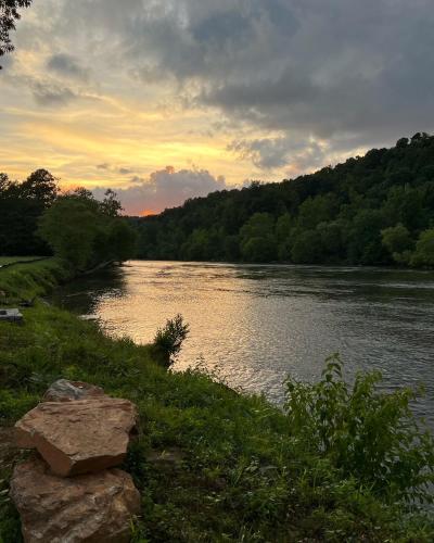 a view of a river with the sunset in the background at Asheville River Cabins in Arden