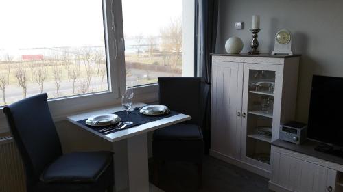 a dining room with a table and a window at FeWo Eggers 1 in Burgtiefe auf Fehmarn 