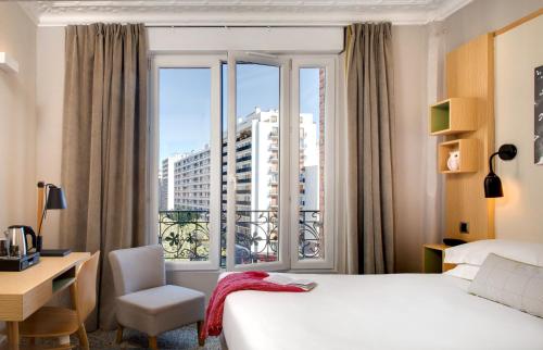 um quarto de hotel com uma cama e uma janela em Chouette Hotel em Paris