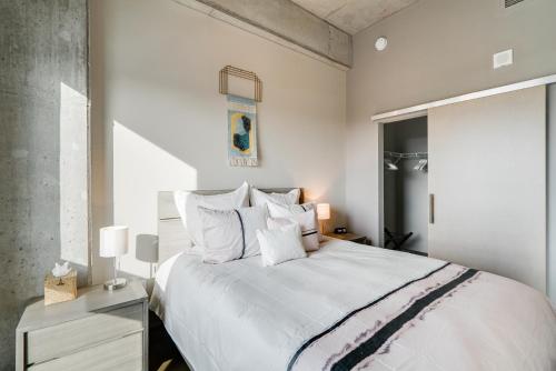 a bedroom with a large bed with white sheets and pillows at Sable 86 in Minneapolis