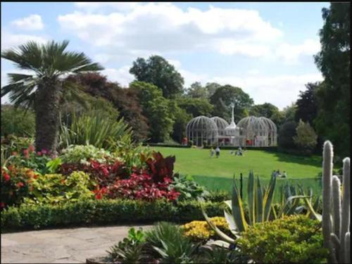 a garden with flowers and a palm tree and a building at FREE Extra Guest. Heart of Birmingham City Centre in Birmingham