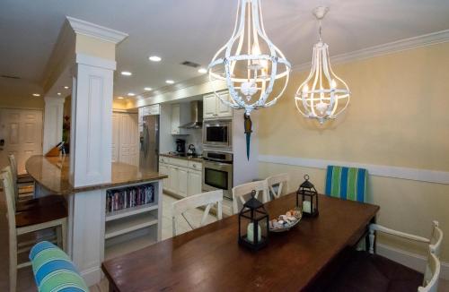 a kitchen with a wooden table and chandeliers at 107 Capt John Fripp III in Fripp Island