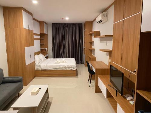 Kleines Zimmer mit einem Bett, einem Schreibtisch und einem TV. in der Unterkunft Spacious High Rise Studio Apartment - By MESA in Nagoya