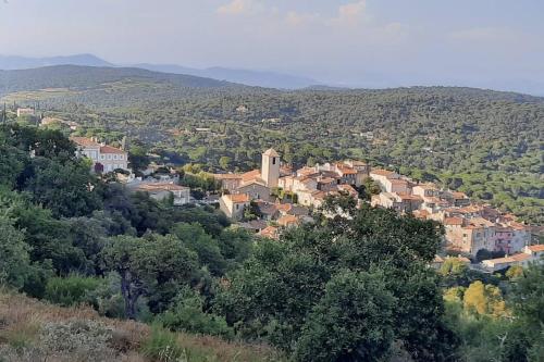małe miasteczko na szczycie wzgórza porośniętego drzewami w obiekcie LES VIGNES ET LA PINEDE PRES DE LA PLAGE w Saint-Tropez