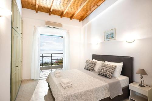 a bedroom with a bed with a view of the ocean at Nissaki Sea View Apartments in Nisakion