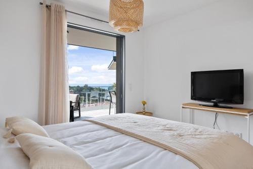 a bedroom with a bed and a tv and a window at Agosta Sea View in Porticcio