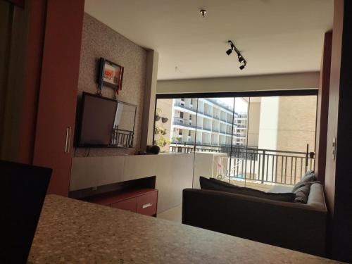 uma sala de estar com uma grande janela e uma televisão em Taguá life apartamento amplo moderno e encantador em Taguatinga