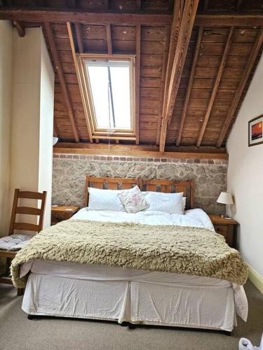 a bedroom with a large bed with a window at Hound Tor Barn Dartmoor in Manaton