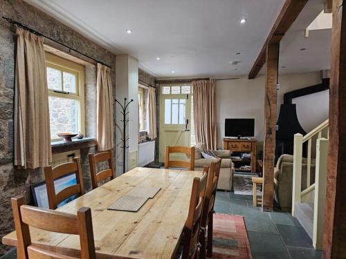 a living room with a wooden table and chairs at Hound Tor Barn Dartmoor in Manaton