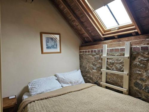 a bedroom with a bed and a brick wall at Hound Tor Barn Dartmoor in Manaton