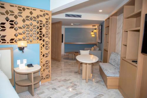 a hotel room with two tables and a couch at Wyndham Grand Cancun All Inclusive Resort & Villas in Cancún