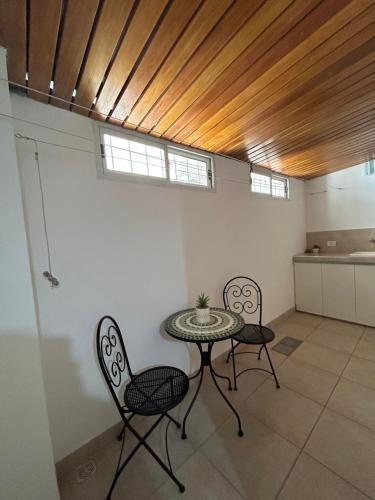 una mesa y 2 sillas en una habitación con techo en Departamento nuevo, planta baja, con patio en Santiago del Estero