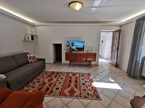 ein Wohnzimmer mit einem Sofa und einem Flachbild-TV in der Unterkunft Casa Vacanze Minula - Indipendent Country House in Carnello