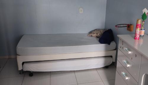 een klein bed in een kleine kamer met een dressoir bij Casa centro - ótima localização - com internet in Primavera do Leste