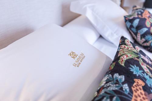 a hotel room with a bed with a pillow and a tie at Hotel Monells Summum in Monells