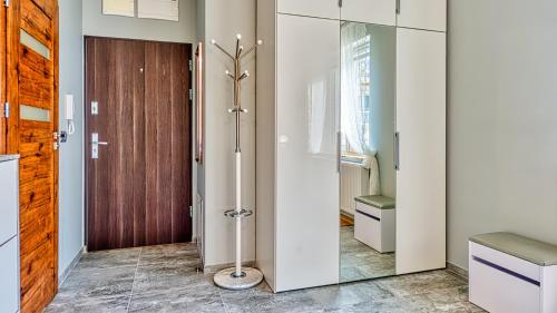 a bathroom with a pivot door and a glass door at Apartament H7 - 5D Apartamenty in Świeradów-Zdrój
