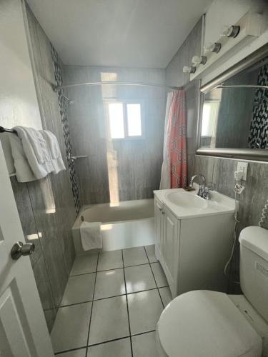 La salle de bains est pourvue d'un lavabo, d'une baignoire et de toilettes. dans l'établissement Walden Motel, à Las Vegas