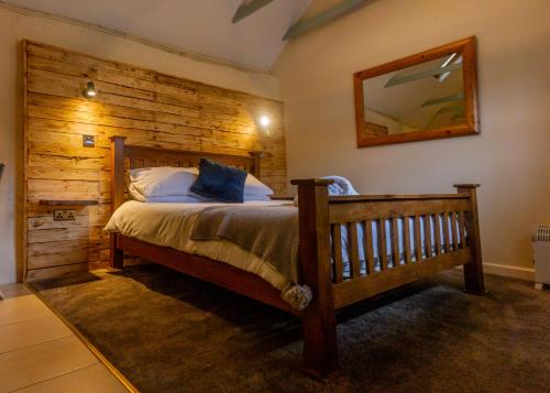 a bedroom with a bed with a wooden wall at Hills Farm Stays in Kilmington