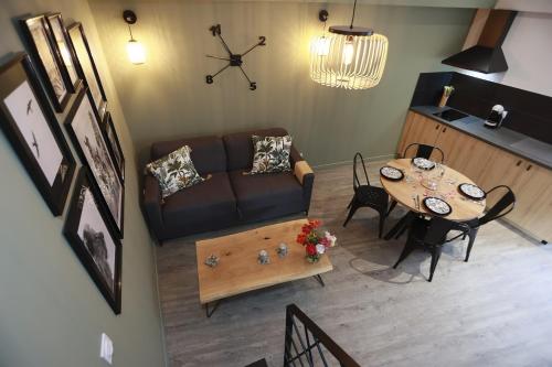 un salon avec un canapé et une table dans l'établissement Maison Le Lodge- Centre Doué la Fontaine proche zoo, à Doué-la-Fontaine