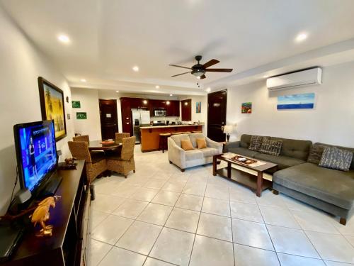 a living room with a couch and a tv at Monte Carlo Luxury Condominiums in Jacó
