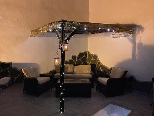 - un salon avec un canapé et des chaises sous un parasol dans l'établissement Casa Rural in Fataga, à San Bartolomé