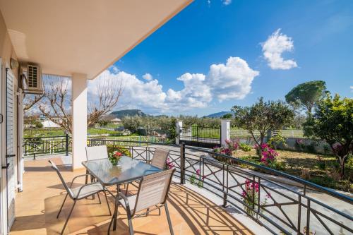 patio con mesa y sillas en el balcón en Barbara Country House, en Zakynthos