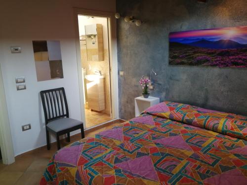 a bedroom with a bed and a chair and a painting at 99 Nolfi in Fano