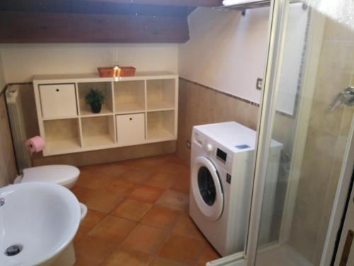 a bathroom with a washing machine and a sink at 99 Nolfi in Fano