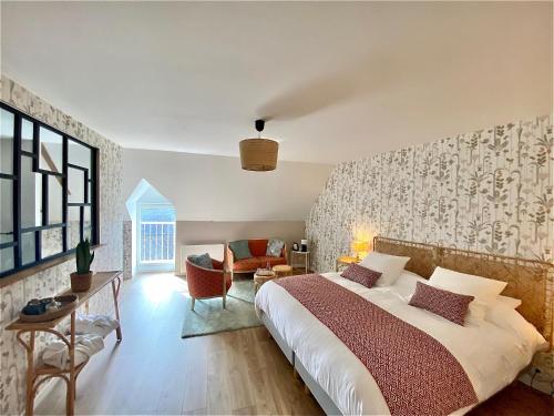 una camera con un grande letto e un soggiorno di Maison Alfred et Agatha a Pleudihen-sur-Rance