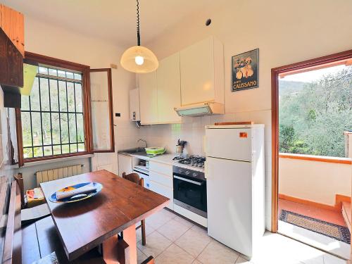 eine Küche mit einem Tisch und einem weißen Kühlschrank in der Unterkunft Tra gli Ulivi e il Mare in Tellaro