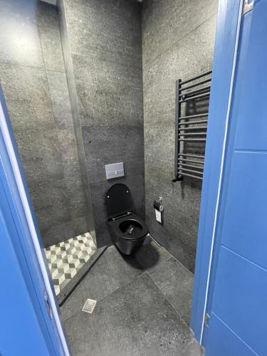 a bathroom with a black toilet in a stall at Villa Residence Apartment2 in Tbilisi City