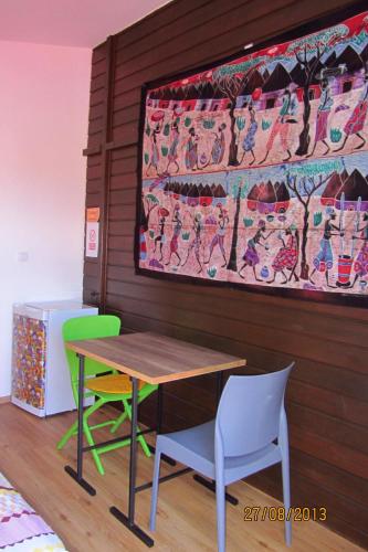 uma mesa e cadeiras e um quadro na parede em Chez Frida em Entre-Deux