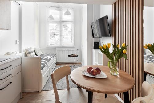 a small white kitchen with a table with a vase of flowers at Długa 18 Apartament Premium z antresolą in Poznań