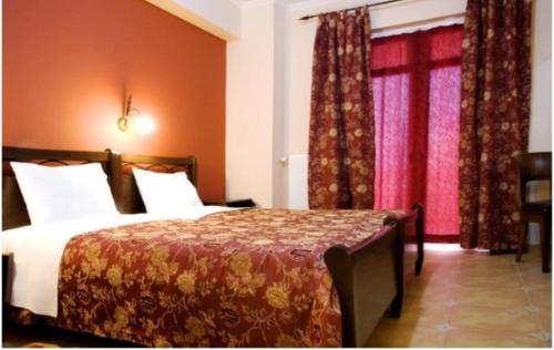 a hotel room with a bed and a window at Palatino in Loutra Edipsou