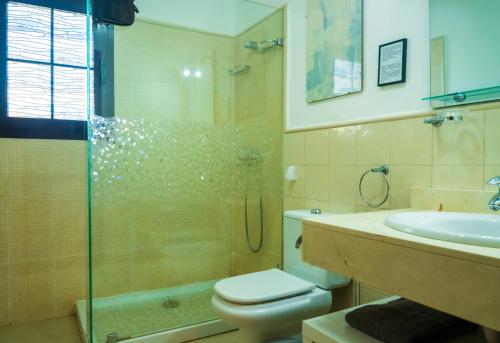 een badkamer met een douche, een toilet en een wastafel bij Dias Felices in Playa Blanca