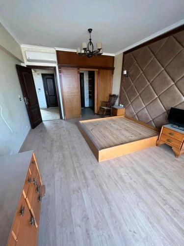 - une chambre avec un grand lit et du parquet dans l'établissement ستانلي اسكندريه, à Alexandrie