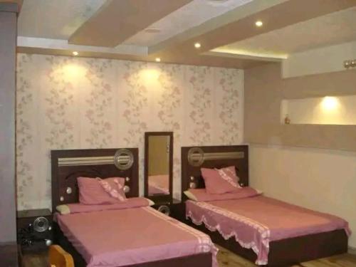 - 2 lits dans une chambre avec des draps roses dans l'établissement ستانلي اسكندريه, à Alexandrie