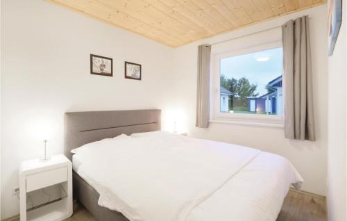 a bedroom with a white bed and a window at Ferienhaus 32 Altefhr in Altefähr